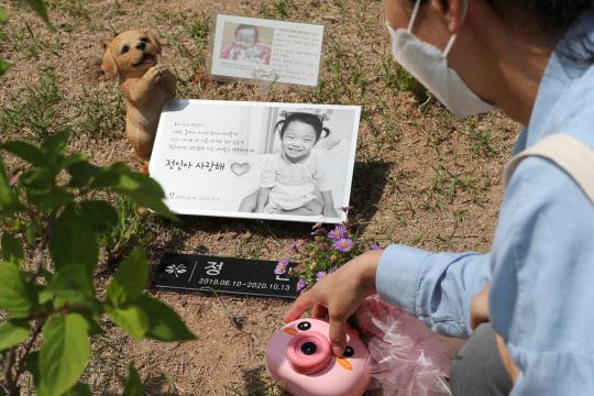 16개월 된 입양아 정인양을 학대해 숨지게 한 혐의를 받는 양부모의 1심 선고공판이 열린 14일 경기도 양평군 하이패밀리 안데르센 공원묘원에서 참배객이 정인양을 추모하고 있다.  연합뉴스